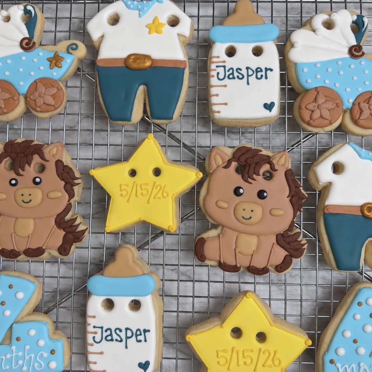 Baby shower cookies with lions, stars, and baby bottles